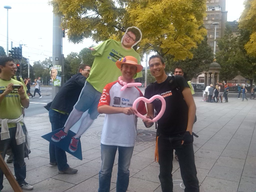 Sebastian Harmel mit einem Piraten-Sympathisanten auf dem Albertplatz. Es wird ein rosa Luftballonherz übergeben.