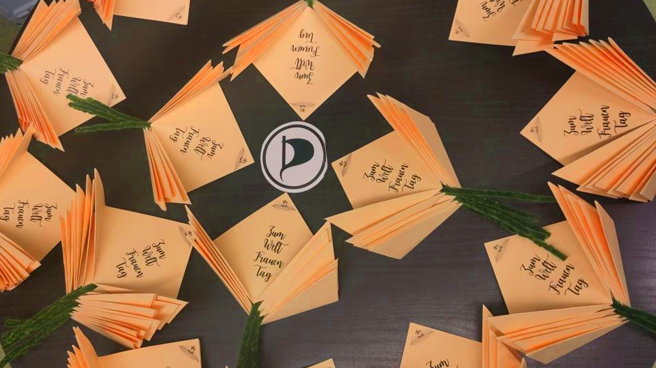 Viele orange Papierpblumen um ein Piraten-P gelegt.