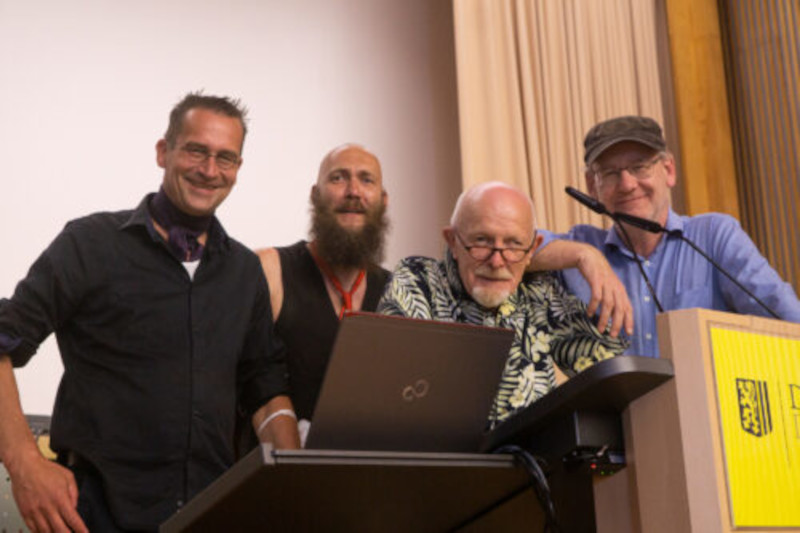 4 Personen stehen in lockerer Pose an einem Rednerpult mit Laptop und Mikrofon vor ihnen. DIe Personen sind von links nach rechts die vier Stadträte Dr. Martin Schulte-Wissermann, Max Aschenbach, Michael Schmelich und Johannes Lichdi