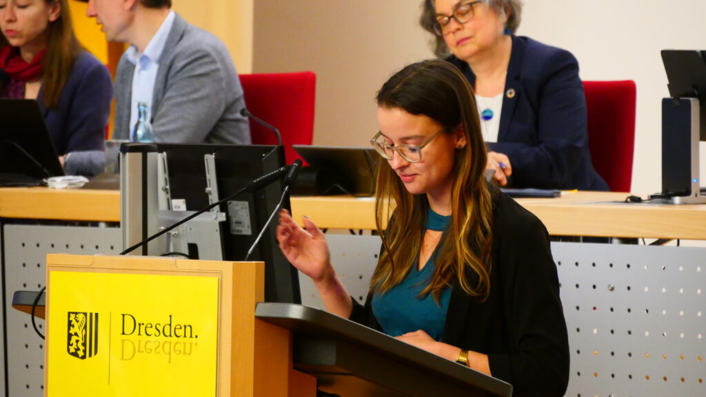 Stadträtin Anne Herpertz an einem Pult im Plenarsaal des Stadtrats Dresden.