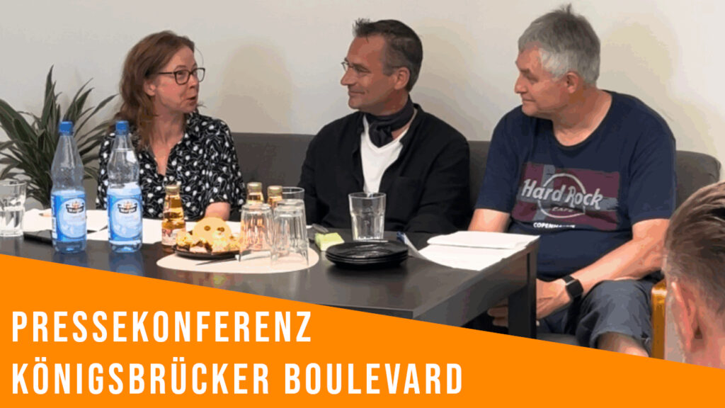 3 Personen sitzen an einem Konferenztisch