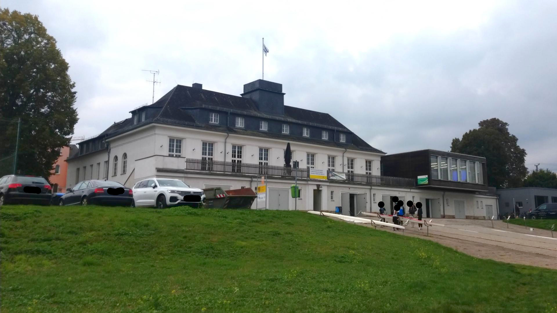 Ein großes Gebäude auf einem grünen Hügel.