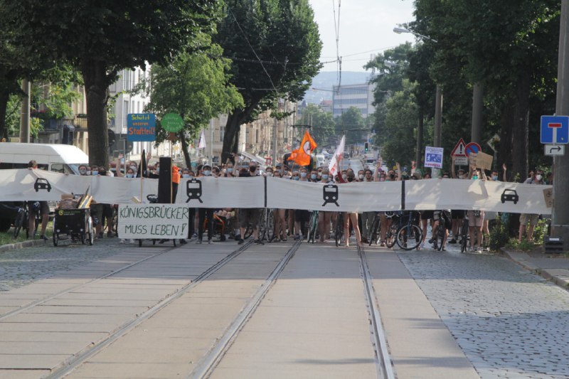 Man sieht wie ein Banner die geplante Straßenbreite darstellt. Bei dieser Breite müssen alle Bäume gefällt werden.